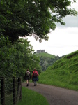 SX16181 Jenni and Margaret walking on road back towards Carreg Cennen Castle on top of distant cliffs.jpg